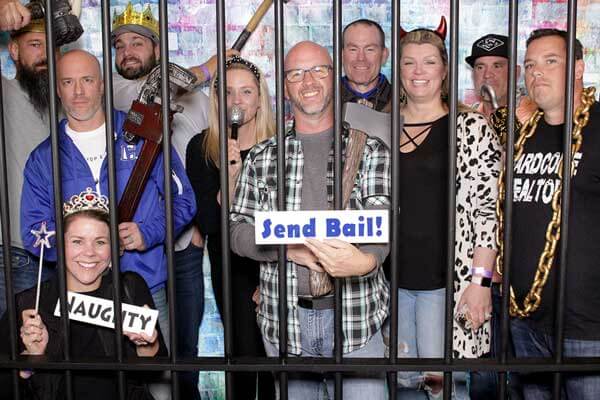 Jailhouse guests behind bars photo booth rental.